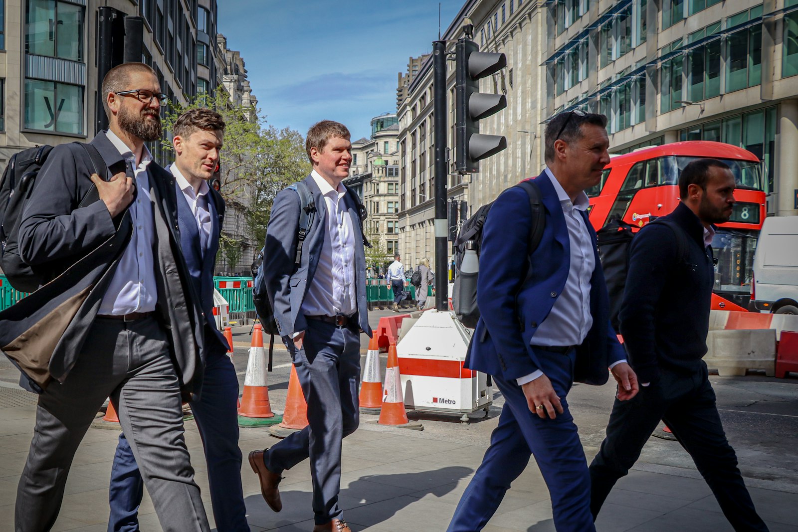 Business professionals in suits crossing a city street