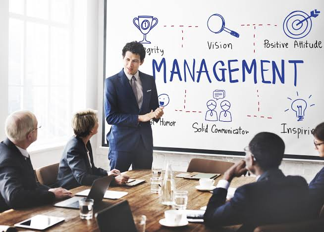 Presenter explaining a management chart to colleagues in a meeting